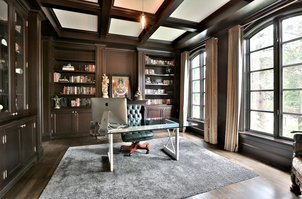 Ejemplo de despacho tradicional de tamaño medio sin chimenea con suelo de madera oscura, escritorio independiente, paredes marrones y suelo marrón