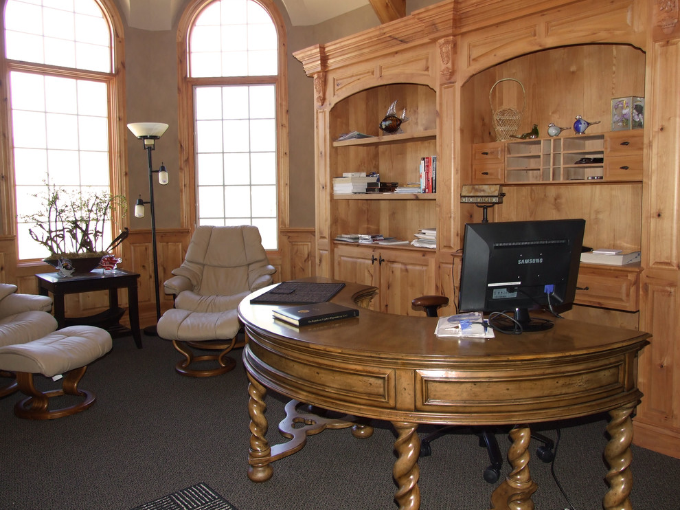 Cette image montre un grand bureau craftsman avec un mur beige, moquette et un bureau indépendant.