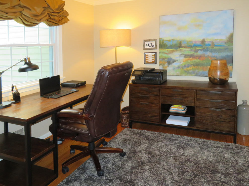 Mittelgroßes Modernes Arbeitszimmer mit Arbeitsplatz, beiger Wandfarbe, braunem Holzboden, freistehendem Schreibtisch und braunem Boden in Sonstige
