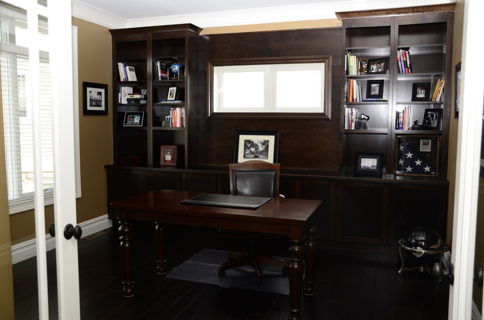 Inredning av ett arbetsrum, med mörkt trägolv och ett fristående skrivbord