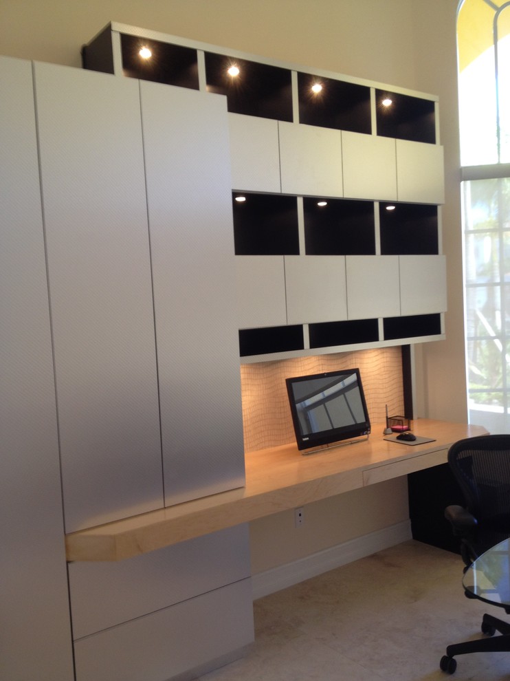 Idéer för mellanstora funkis arbetsrum, med ett bibliotek, beige väggar, kalkstensgolv, ett inbyggt skrivbord och beiget golv
