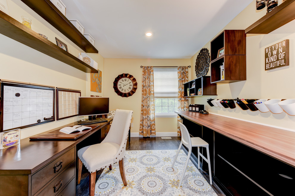 Exemple d'un petit bureau chic avec un mur jaune, parquet foncé, aucune cheminée et un bureau indépendant.