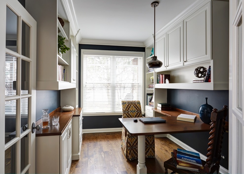 Design ideas for a small contemporary study in Chicago with blue walls, dark hardwood flooring and a built-in desk.