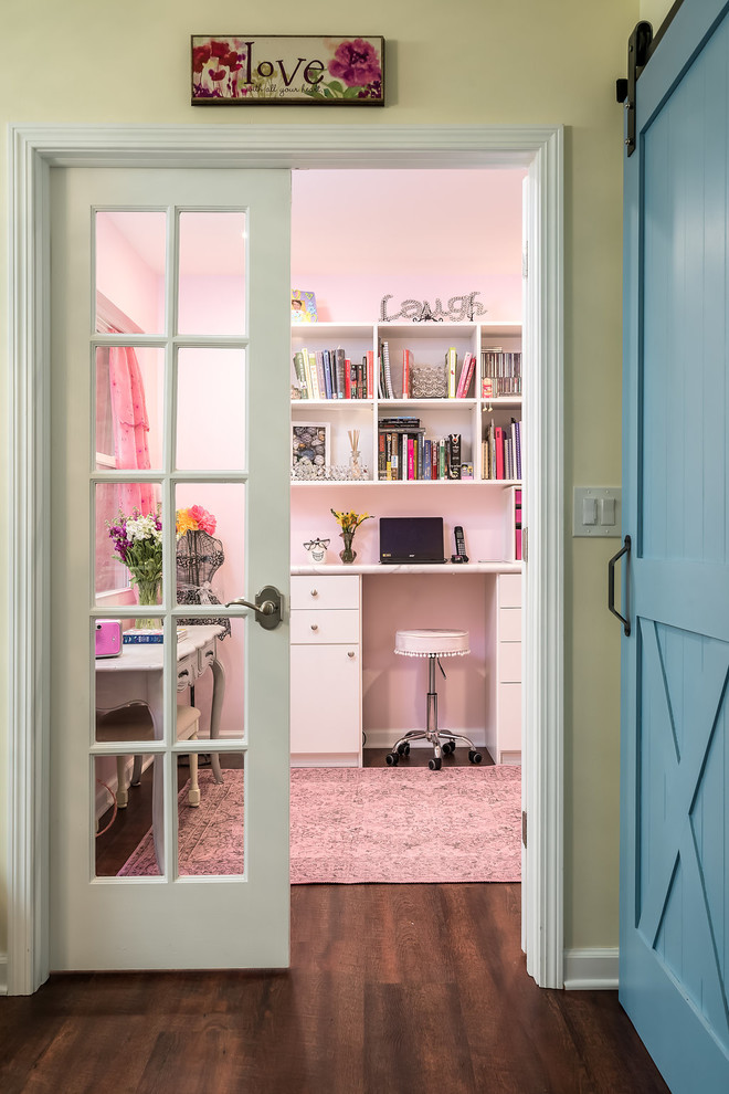 Ejemplo de despacho ecléctico de tamaño medio con paredes rosas, suelo vinílico, escritorio independiente y suelo marrón