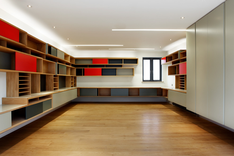 Esempio di un grande atelier contemporaneo con pareti bianche, pavimento in legno massello medio e scrivania incassata