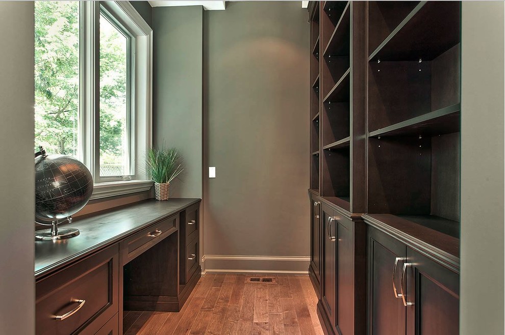 Mittelgroßes Klassisches Lesezimmer ohne Kamin mit grauer Wandfarbe, dunklem Holzboden und Einbau-Schreibtisch in Toronto
