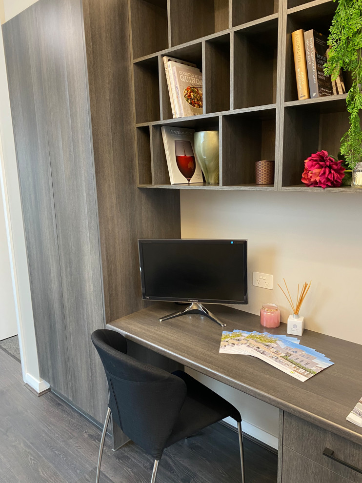 Example of a mid-sized trendy built-in desk laminate floor study room design in Adelaide with white walls