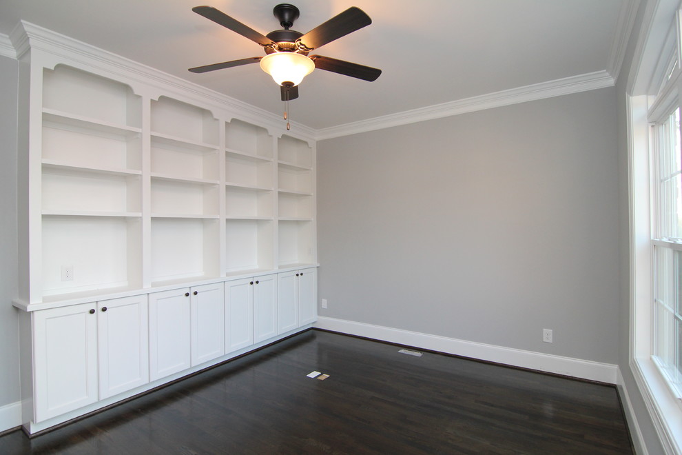Imagen de despacho clásico grande con paredes grises y suelo de madera en tonos medios