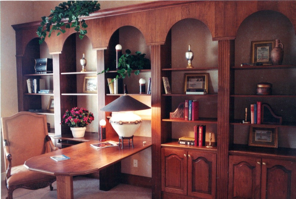 タンパにある高級な広いトランジショナルスタイルのおしゃれなホームオフィス・書斎 (ライブラリー、ベージュの壁、カーペット敷き、造り付け机、ベージュの床) の写真