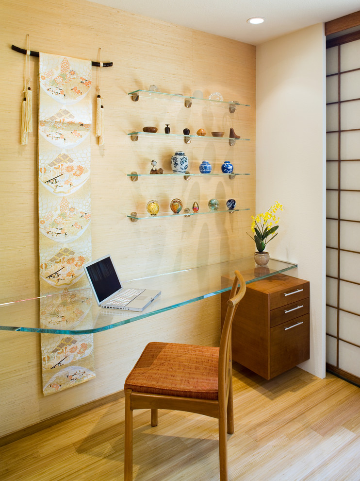 Réalisation d'un bureau asiatique avec un mur beige, un sol en bois brun et un bureau intégré.