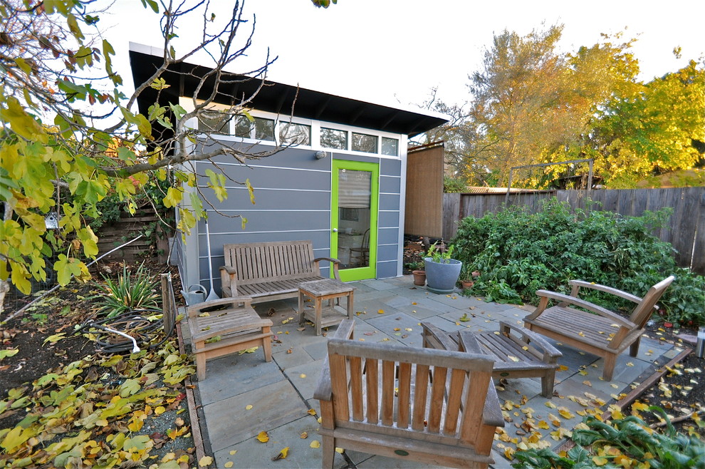 На фото: маленькая домашняя мастерская в современном стиле с серыми стенами, полом из ламината и отдельно стоящим рабочим столом для на участке и в саду