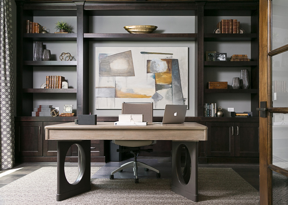 Klassisches Arbeitszimmer ohne Kamin mit Arbeitsplatz, grauer Wandfarbe, dunklem Holzboden und freistehendem Schreibtisch in Tampa