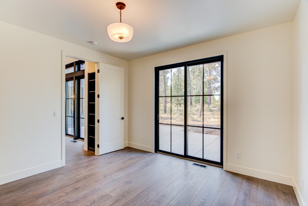 Example of a mid-sized country light wood floor and beige floor study room design with white walls and no fireplace