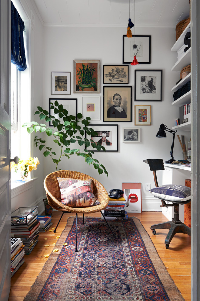 Stilmix Arbeitszimmer ohne Kamin mit weißer Wandfarbe, braunem Holzboden und Einbau-Schreibtisch in Sonstige
