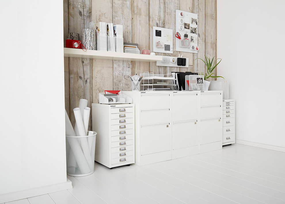 Geräumiges Modernes Arbeitszimmer mit Arbeitsplatz, weißer Wandfarbe und gebeiztem Holzboden in Sonstige