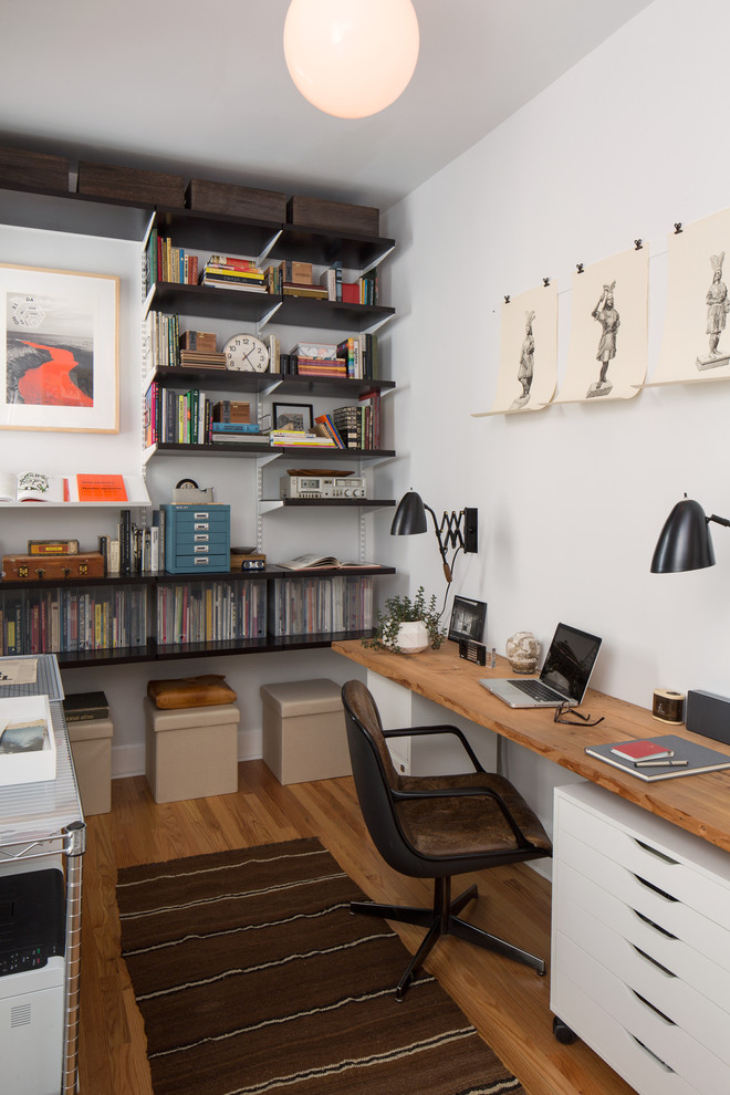 Immagine di un ufficio minimalista con pareti bianche, parquet chiaro e scrivania autoportante