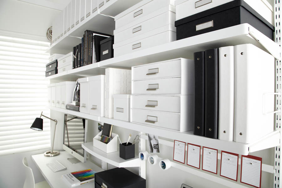 Diseño de estudio moderno de tamaño medio con paredes blancas, suelo de madera oscura y escritorio empotrado