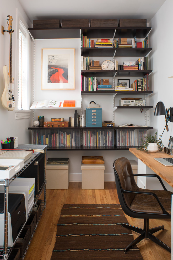 Foto di un ufficio minimalista con pareti bianche, parquet chiaro e scrivania autoportante