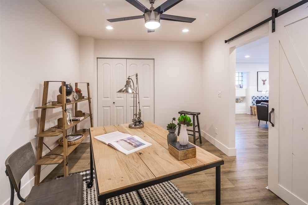 Imagen de despacho campestre de tamaño medio sin chimenea con paredes blancas, suelo de madera en tonos medios y escritorio independiente