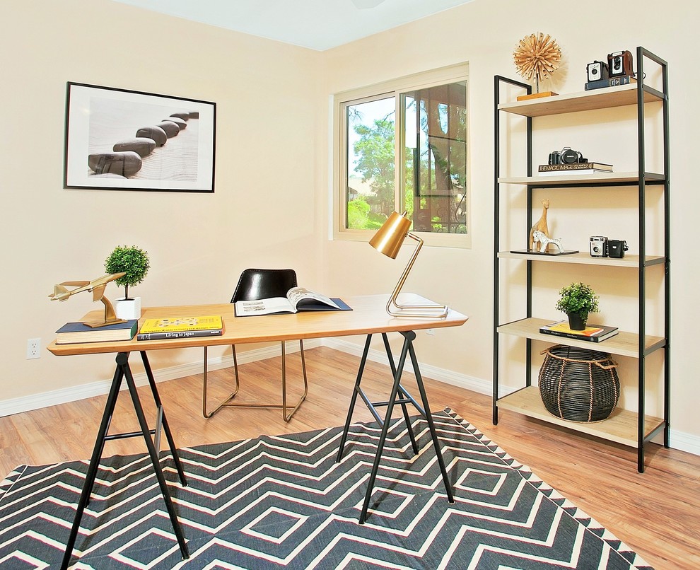Mittelgroßes Stilmix Arbeitszimmer ohne Kamin mit Arbeitsplatz, beiger Wandfarbe, braunem Holzboden und freistehendem Schreibtisch in San Diego