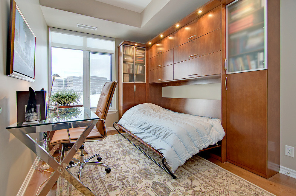 Modernes Arbeitszimmer mit beiger Wandfarbe, braunem Holzboden und freistehendem Schreibtisch in Ottawa