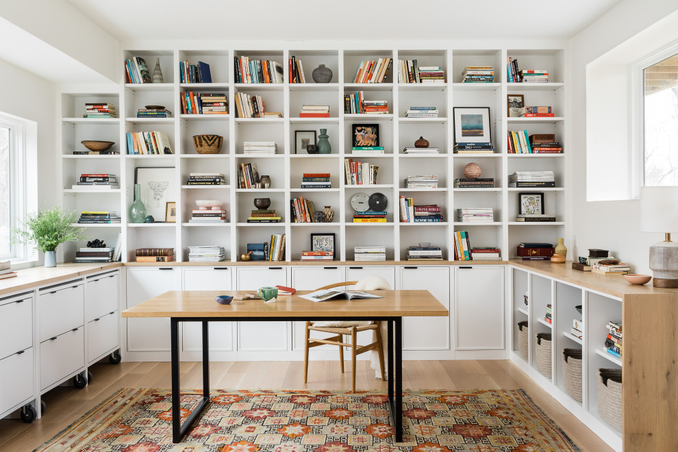 ボストンにあるコンテンポラリースタイルのおしゃれなホームオフィス・書斎 (白い壁、淡色無垢フローリング、自立型机、ベージュの床) の写真