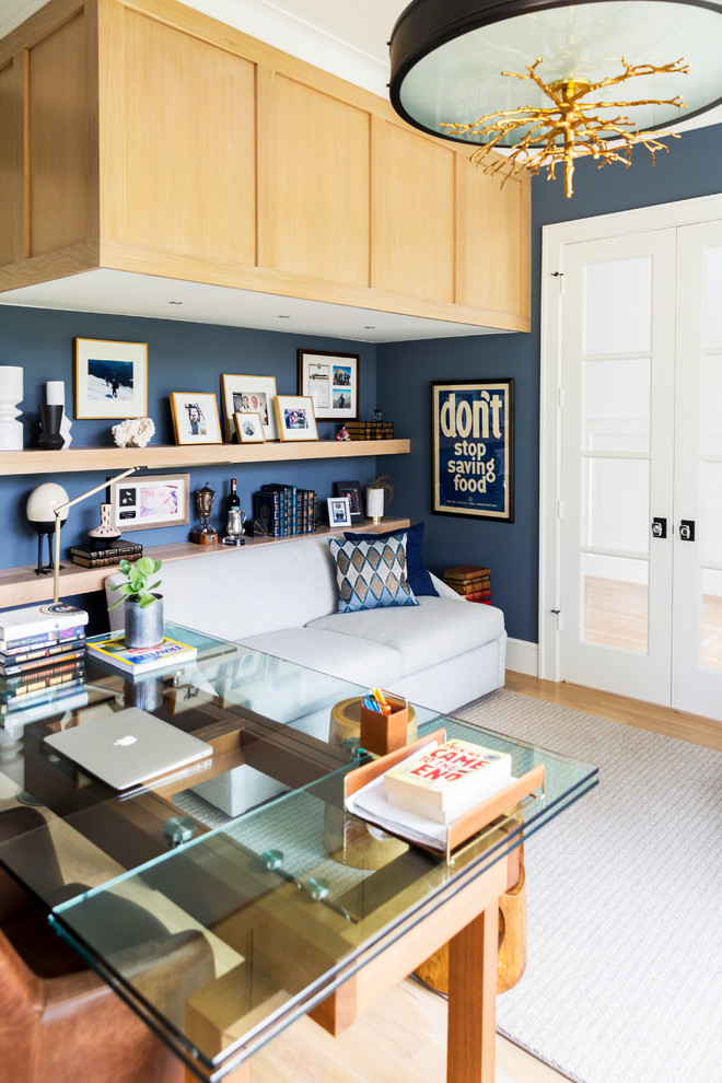 Modelo de despacho clásico renovado de tamaño medio con paredes azules, suelo de madera en tonos medios, escritorio independiente y suelo beige