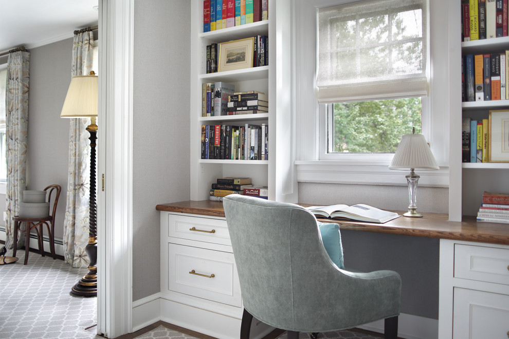 This is an example of a medium sized classic study in Newark with grey walls, carpet, a built-in desk and beige floors.