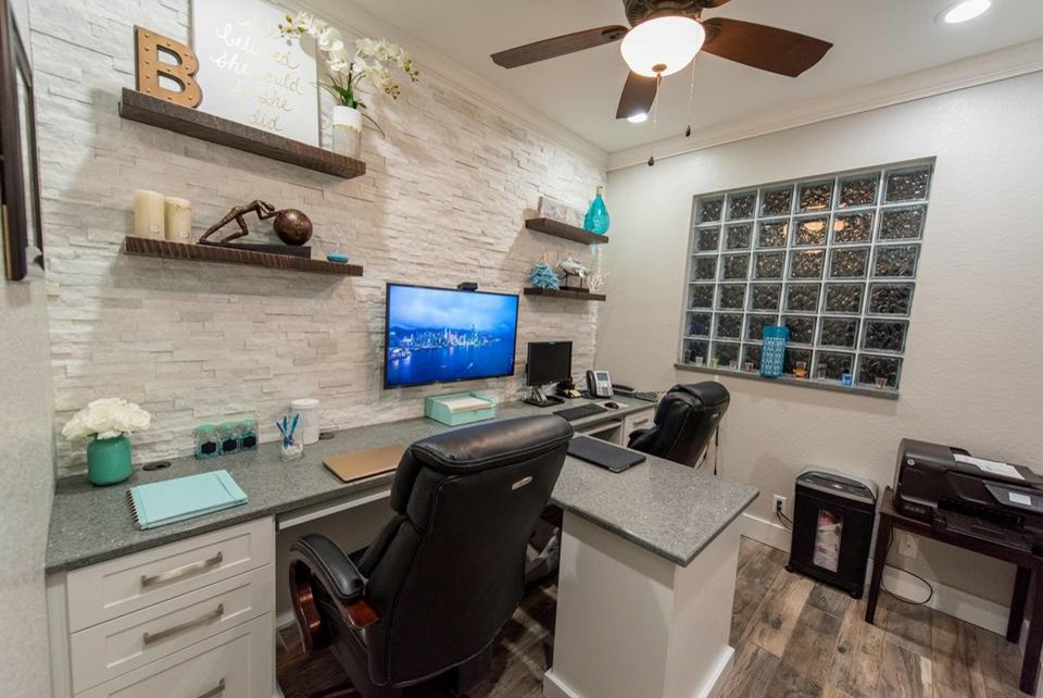 Small modern home office in Miami with white walls, medium hardwood flooring, a built-in desk and brown floors.