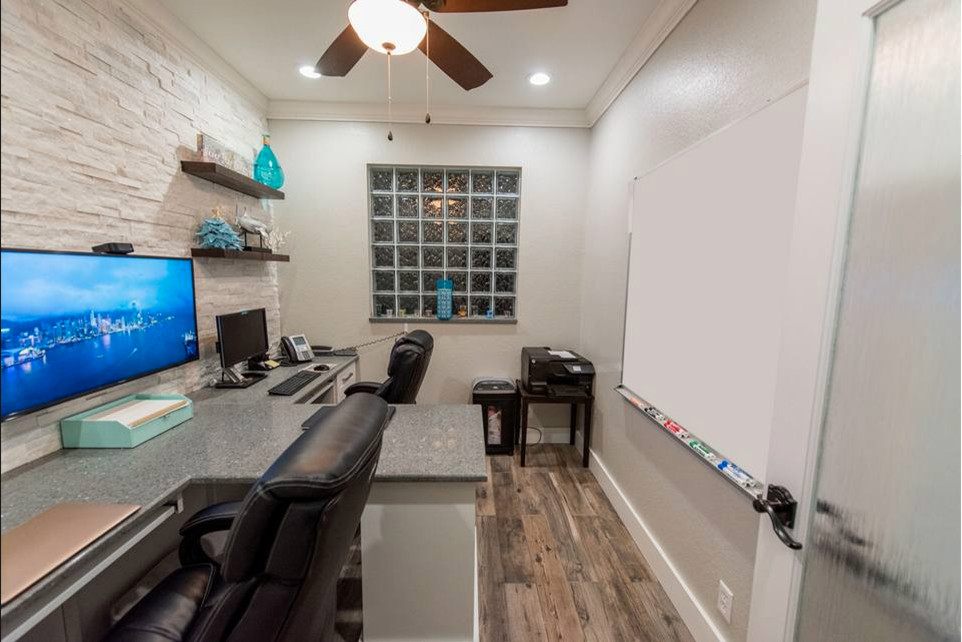 Example of a small minimalist built-in desk medium tone wood floor and brown floor home office design in Miami with white walls