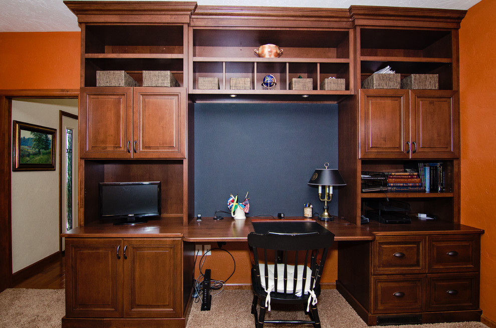 他の地域にある小さなトラディショナルスタイルのおしゃれなホームオフィス・書斎 (オレンジの壁、カーペット敷き、造り付け机、ベージュの床) の写真