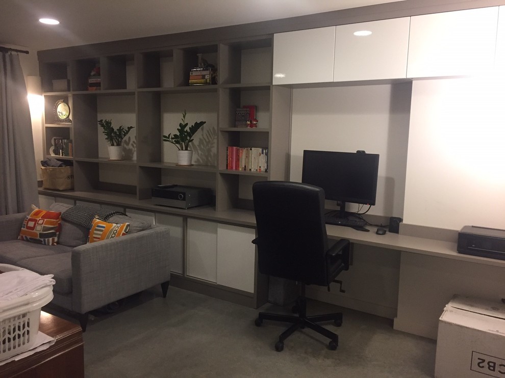 Imagen de despacho minimalista de tamaño medio con paredes blancas, suelo de cemento y escritorio empotrado