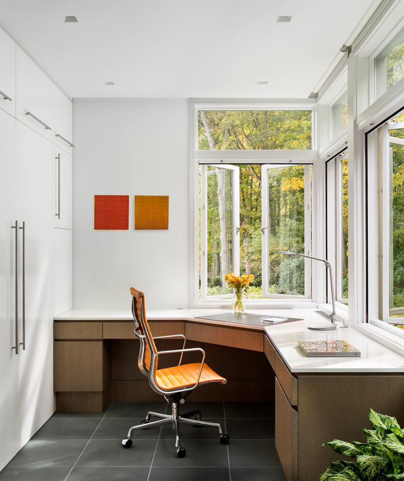 Diseño de despacho contemporáneo con paredes blancas, suelo de baldosas de porcelana y escritorio empotrado