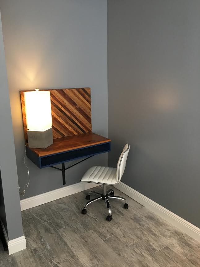 Kleines Modernes Arbeitszimmer ohne Kamin mit Studio, grauer Wandfarbe, hellem Holzboden, Einbau-Schreibtisch und grauem Boden in New Orleans