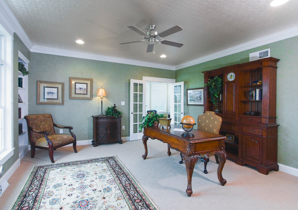 Großes Klassisches Arbeitszimmer mit Arbeitsplatz, grüner Wandfarbe, Teppichboden und freistehendem Schreibtisch in Sonstige