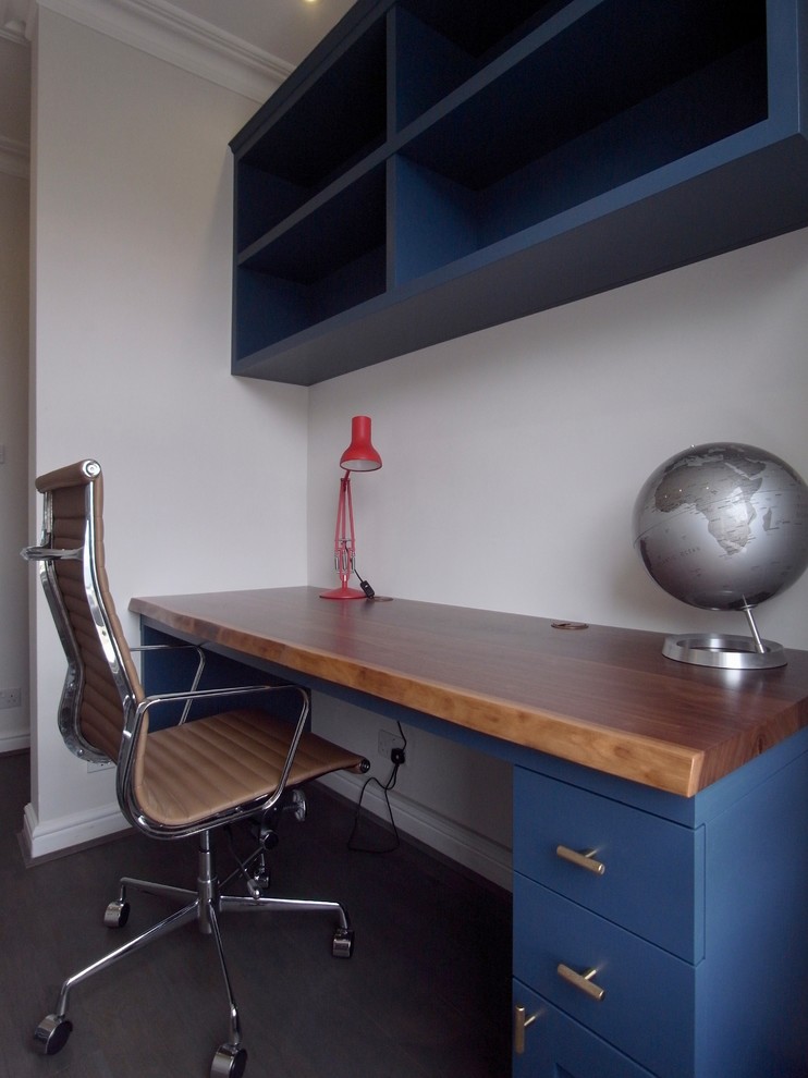 This is an example of a small eclectic study in London with grey walls, dark hardwood flooring and a built-in desk.