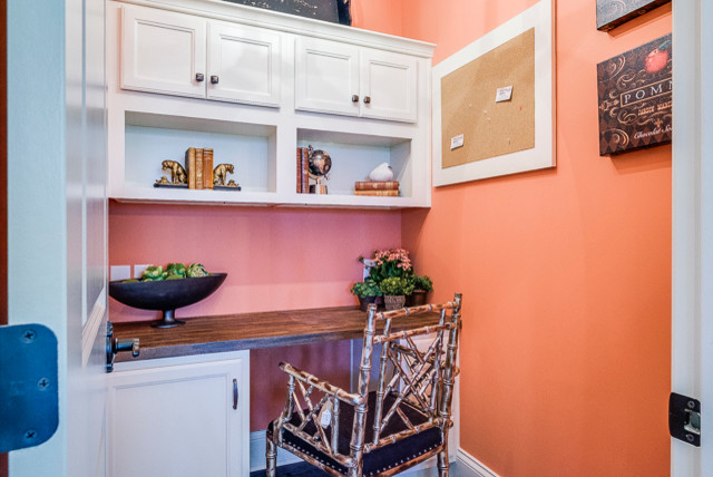 Ejemplo de despacho clásico renovado pequeño con parades naranjas, suelo de madera oscura y escritorio empotrado
