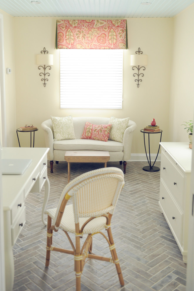 Imagen de despacho tradicional renovado pequeño con paredes amarillas, suelo de baldosas de cerámica, escritorio independiente y suelo gris