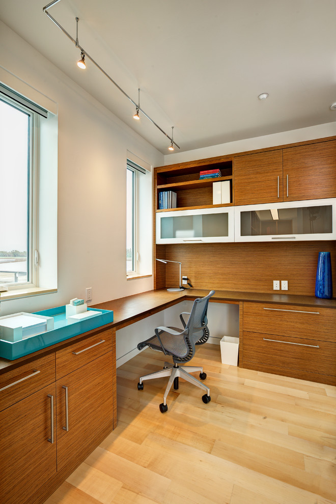 Foto de despacho actual de tamaño medio sin chimenea con paredes blancas, suelo de madera clara, escritorio empotrado y suelo beige