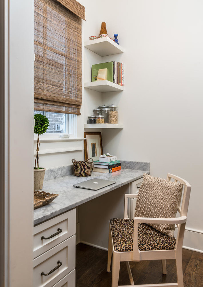 Cette photo montre un bureau chic avec un mur blanc, parquet foncé, un bureau intégré et un sol marron.