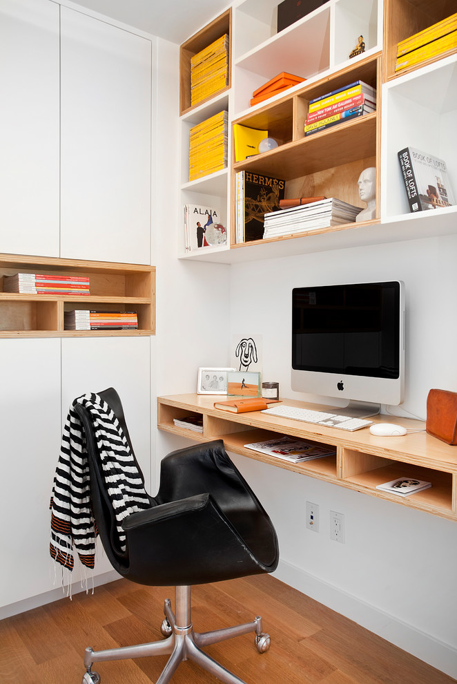 Diseño de despacho actual de tamaño medio sin chimenea con paredes blancas, suelo de madera en tonos medios, escritorio empotrado y suelo marrón