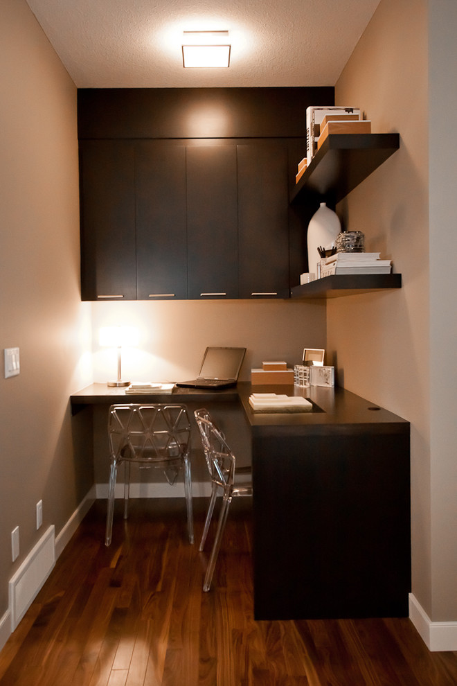 Foto på ett litet funkis arbetsrum, med bruna väggar, mellanmörkt trägolv, en standard öppen spis, en spiselkrans i trä och ett inbyggt skrivbord