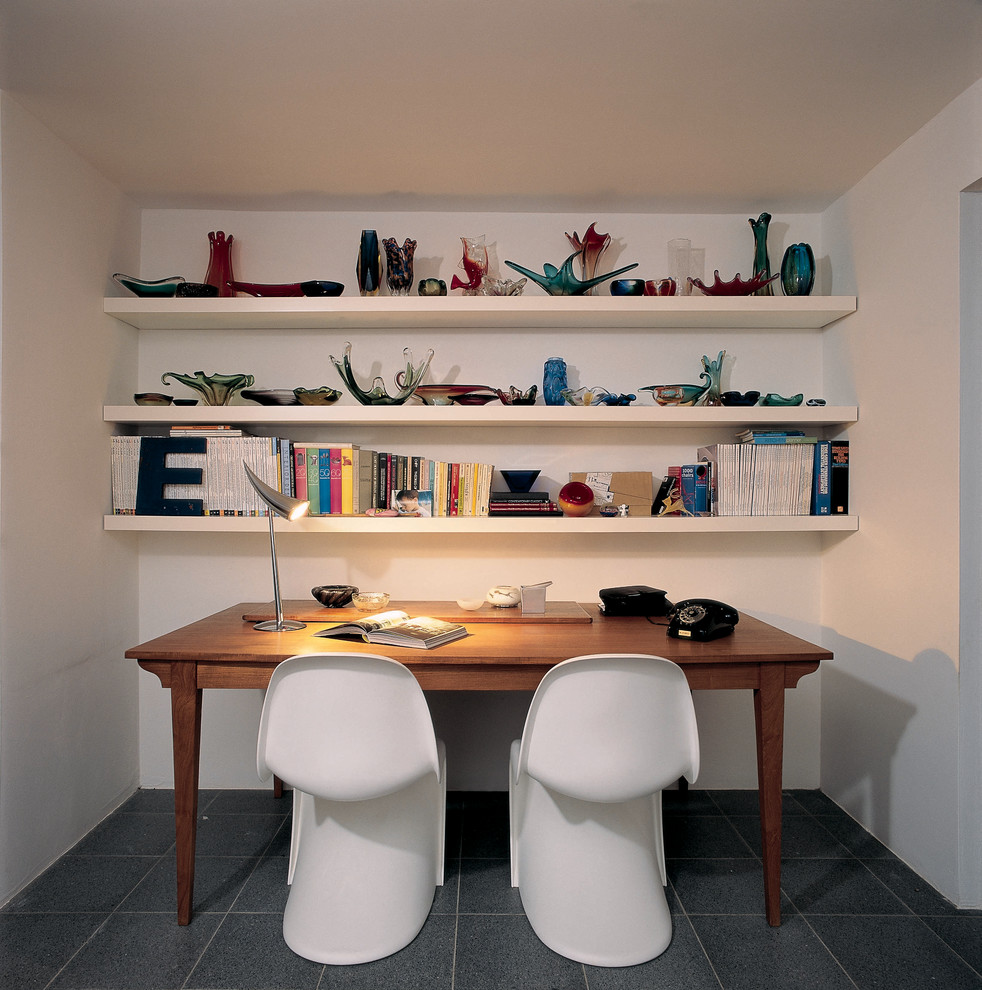 This is an example of a contemporary home office in Other with white walls.