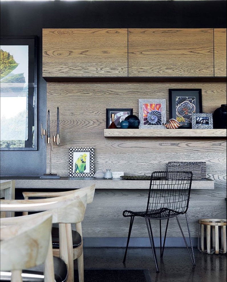他の地域にある中くらいなコンテンポラリースタイルのおしゃれな書斎 (青い壁、造り付け机、黒い床) の写真