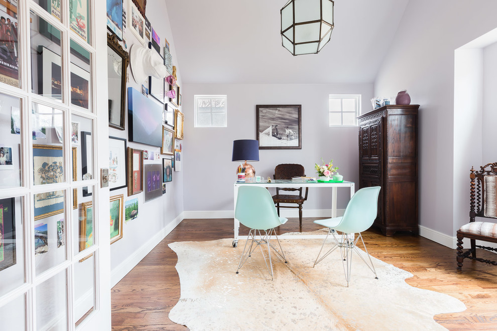 Eklektisk inredning av ett mellanstort arbetsrum, med mellanmörkt trägolv, ett fristående skrivbord, grå väggar och brunt golv