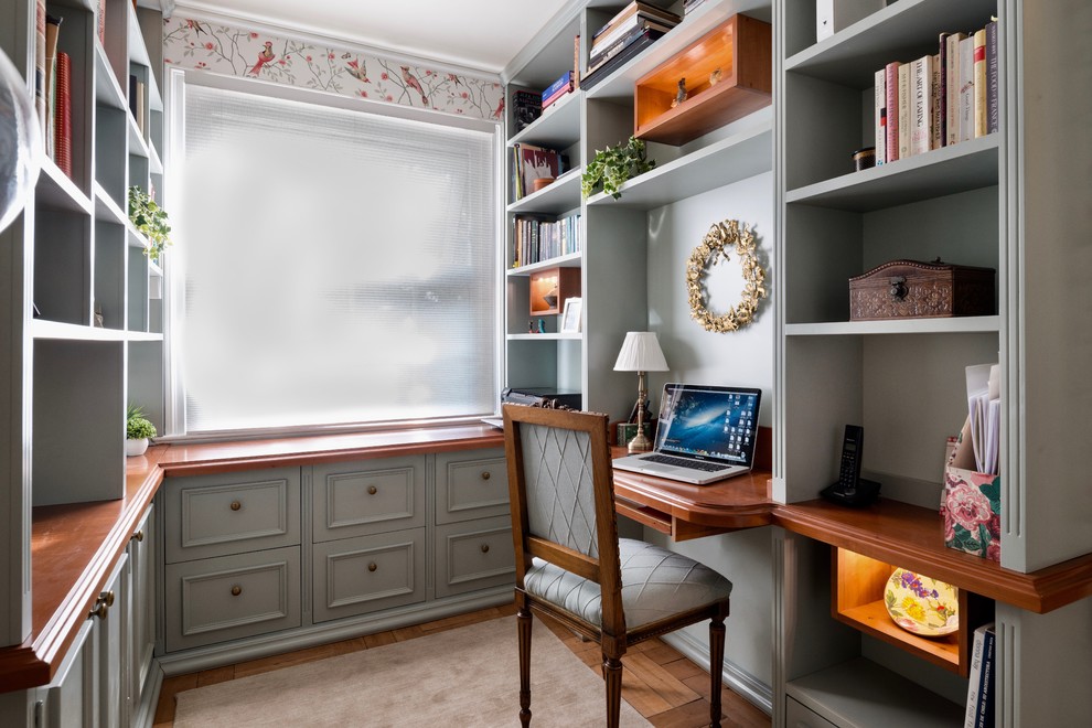 На фото: кабинет в классическом стиле с разноцветными стенами, паркетным полом среднего тона, встроенным рабочим столом и коричневым полом с