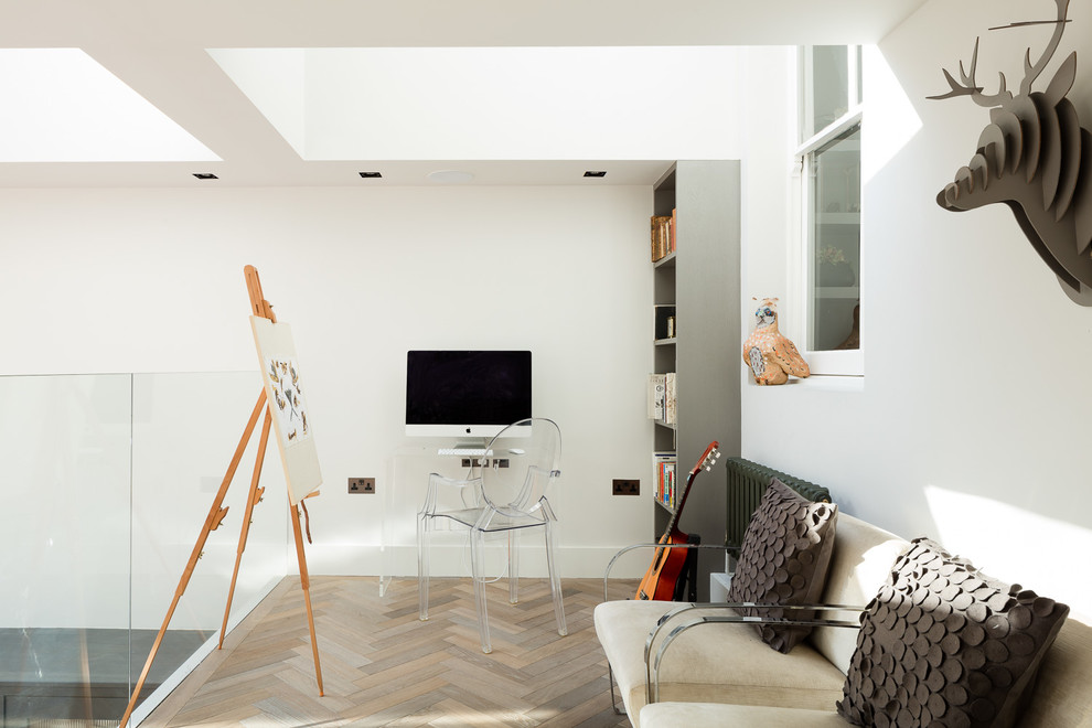 Exempel på ett modernt arbetsrum, med vita väggar, mellanmörkt trägolv och ett fristående skrivbord