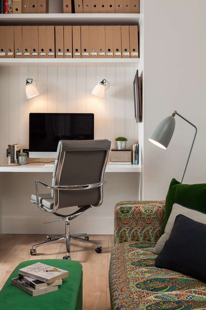 Mittelgroßes Klassisches Arbeitszimmer mit Arbeitsplatz, weißer Wandfarbe, braunem Holzboden, Einbau-Schreibtisch und beigem Boden in London