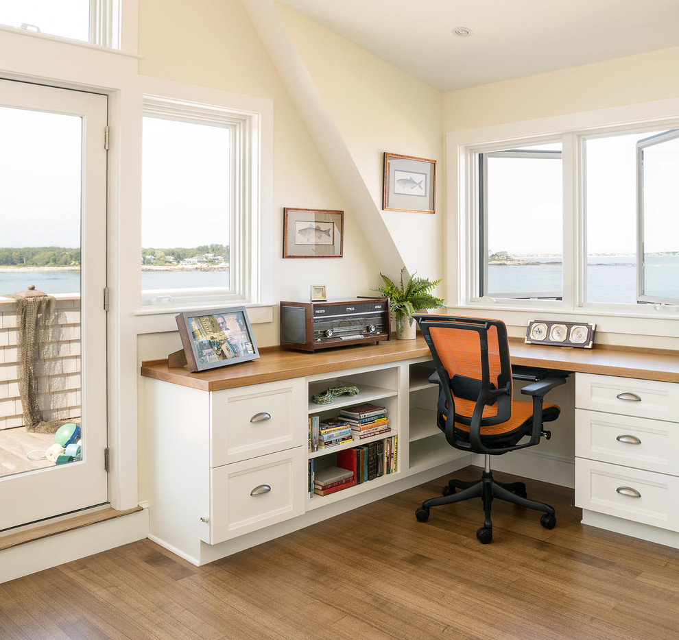 Maritimes Arbeitszimmer mit Einbau-Schreibtisch, beiger Wandfarbe und braunem Holzboden in Portland Maine