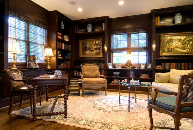 Großes Klassisches Arbeitszimmer mit Arbeitsplatz, brauner Wandfarbe, braunem Holzboden und freistehendem Schreibtisch in Houston